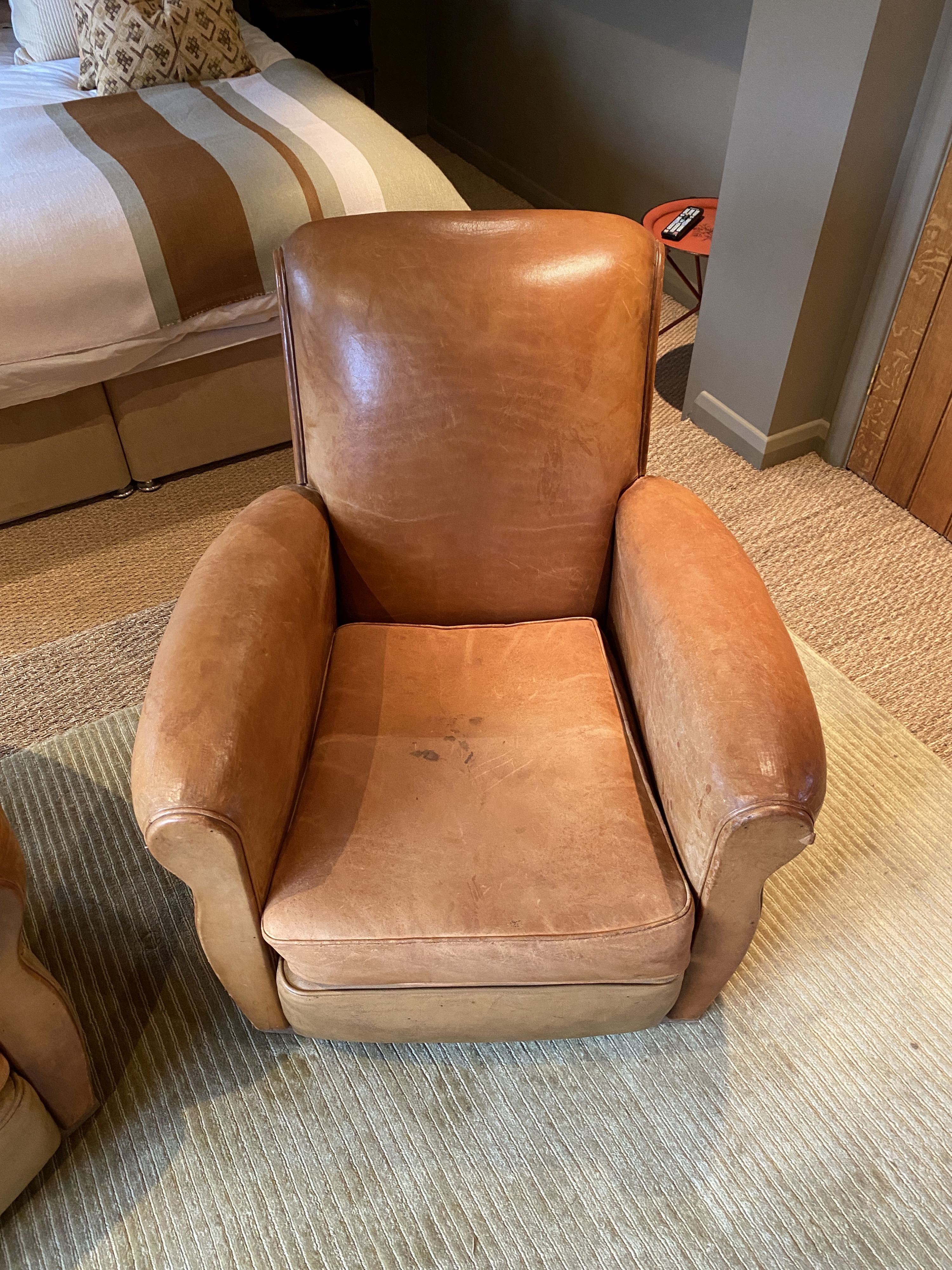 A pair of 1940's French tan leather upholstered armchairs, width 82cm depth 92cm height 84cm